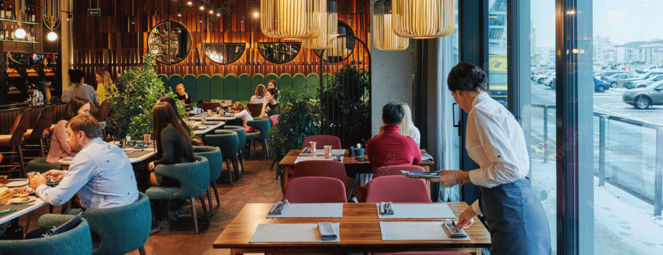 Cozy Restaurant With People and Waiter